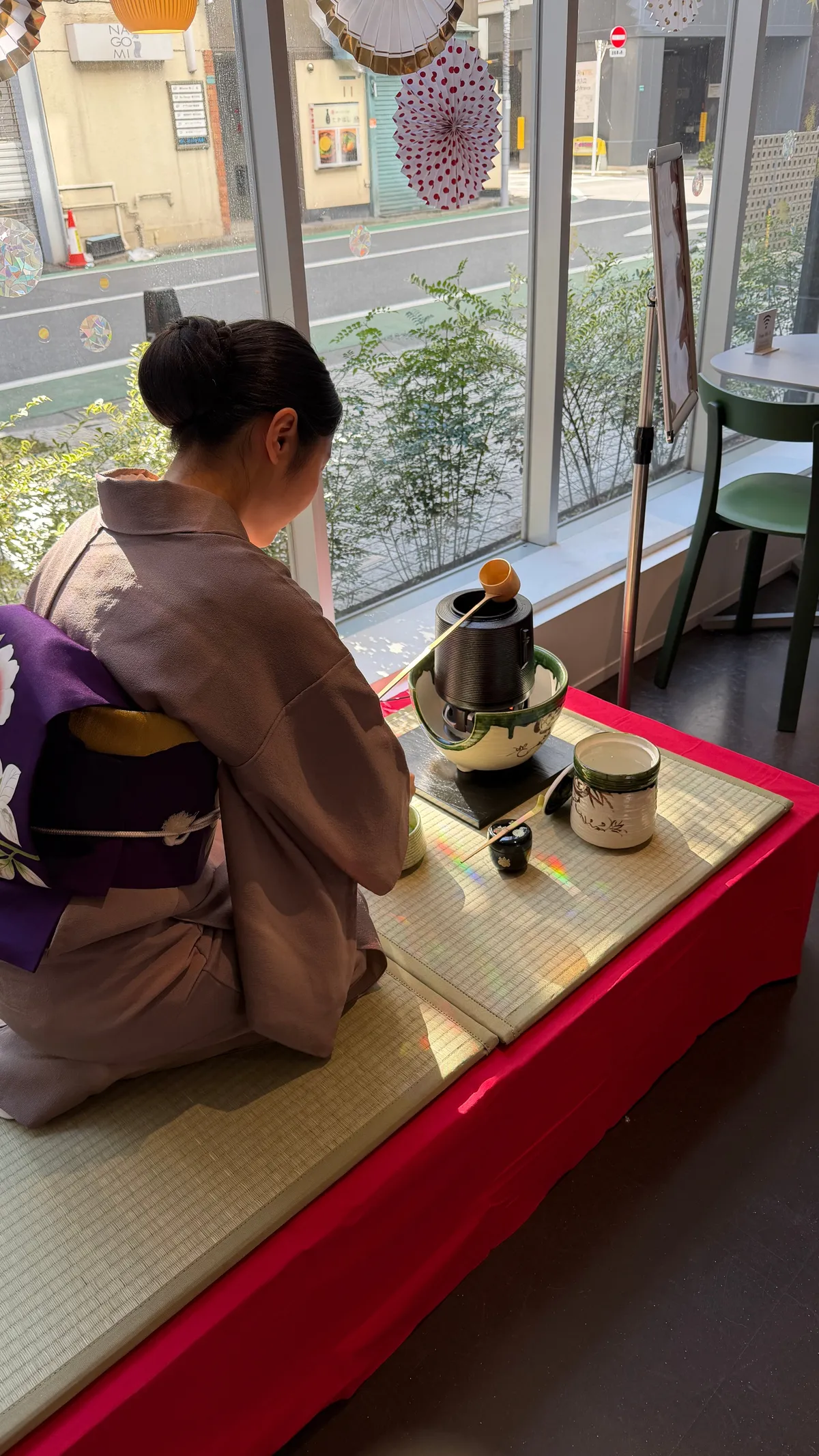 畳の和室で着物姿の女性が抹茶を点てる茶道体験
